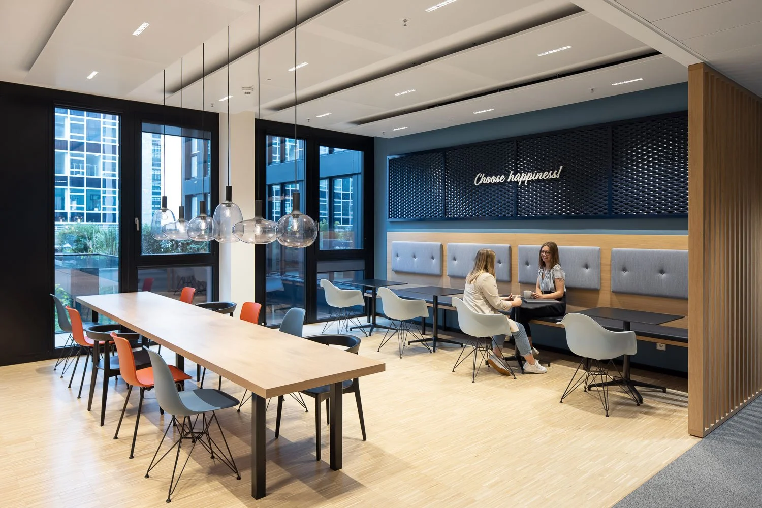 Interior-Fotografie einer modernen Büro-Lounge- und Essbereich mit Vitra Eames Side Chairs und hochwertiger Möblierung als Social Space im New-Work-Office.
