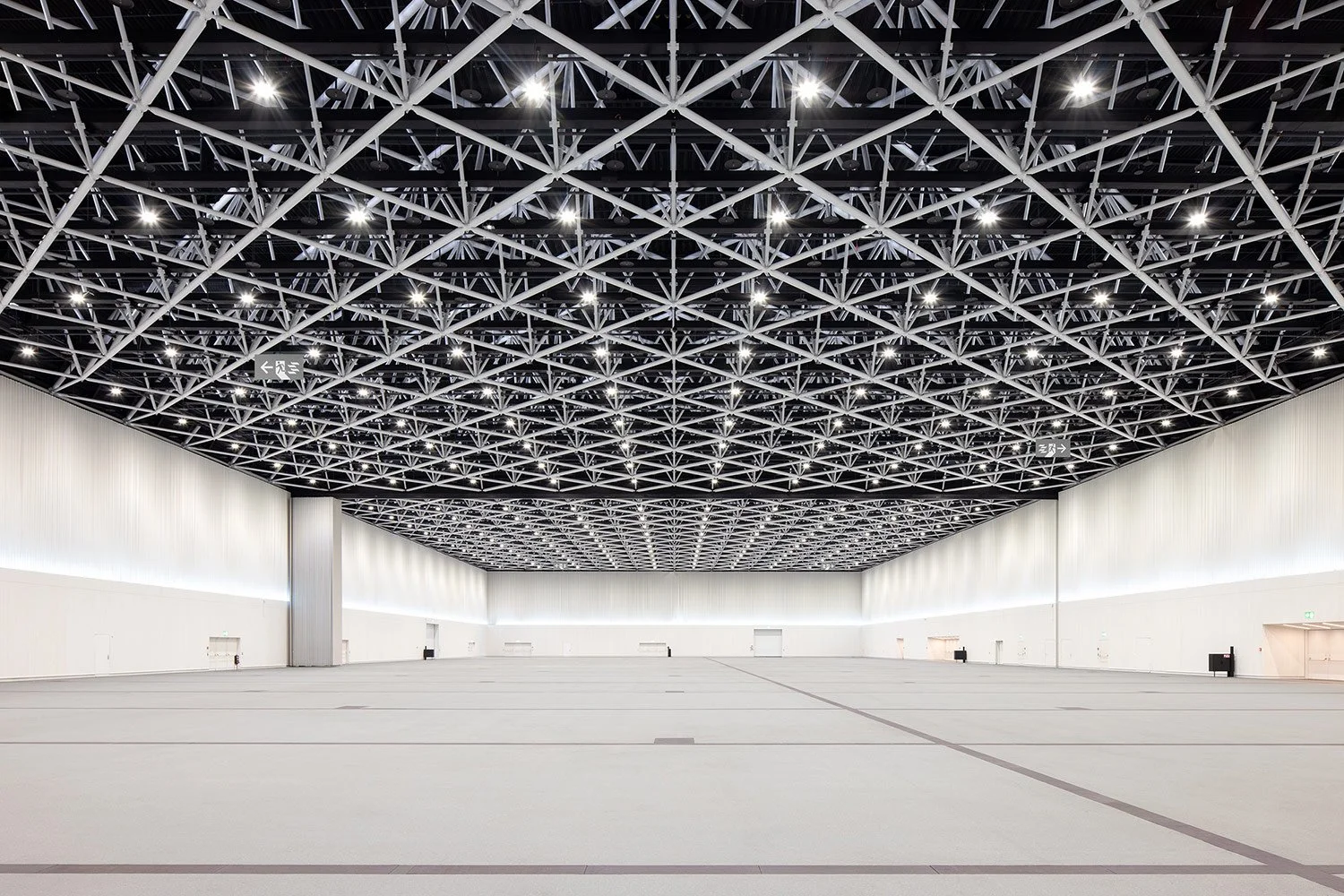 Weitwinkelaufnahme der stützenfreien Eventhalle der SGKB Halle St. Gallen mit weitläufigem Innenraum und markanter Dachstruktur.
