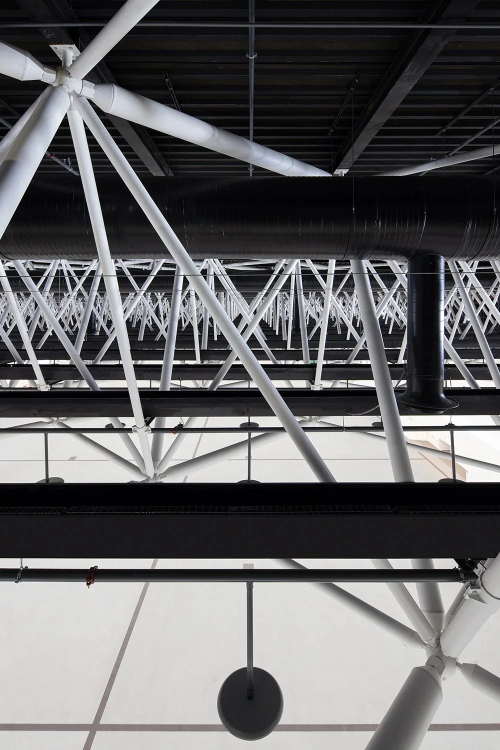 Innenraumansicht des Hallendachs der SGKB Halle St. Gallen mit dichter Stahlbaukonstruktion und rhythmischer Tragstruktur.
