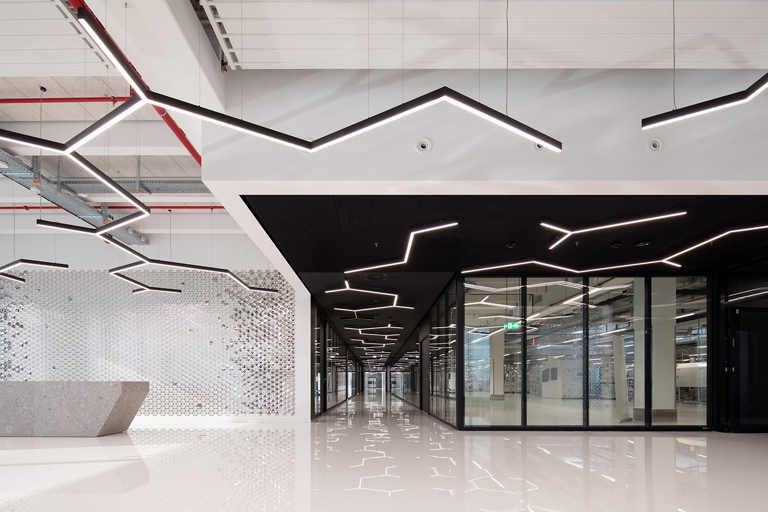 Lobby- und Empfangsbereich der Engelbert Strauss CI Factory mit Blick auf die gläserne Schuhproduktion und moderne Innenarchitektur.
