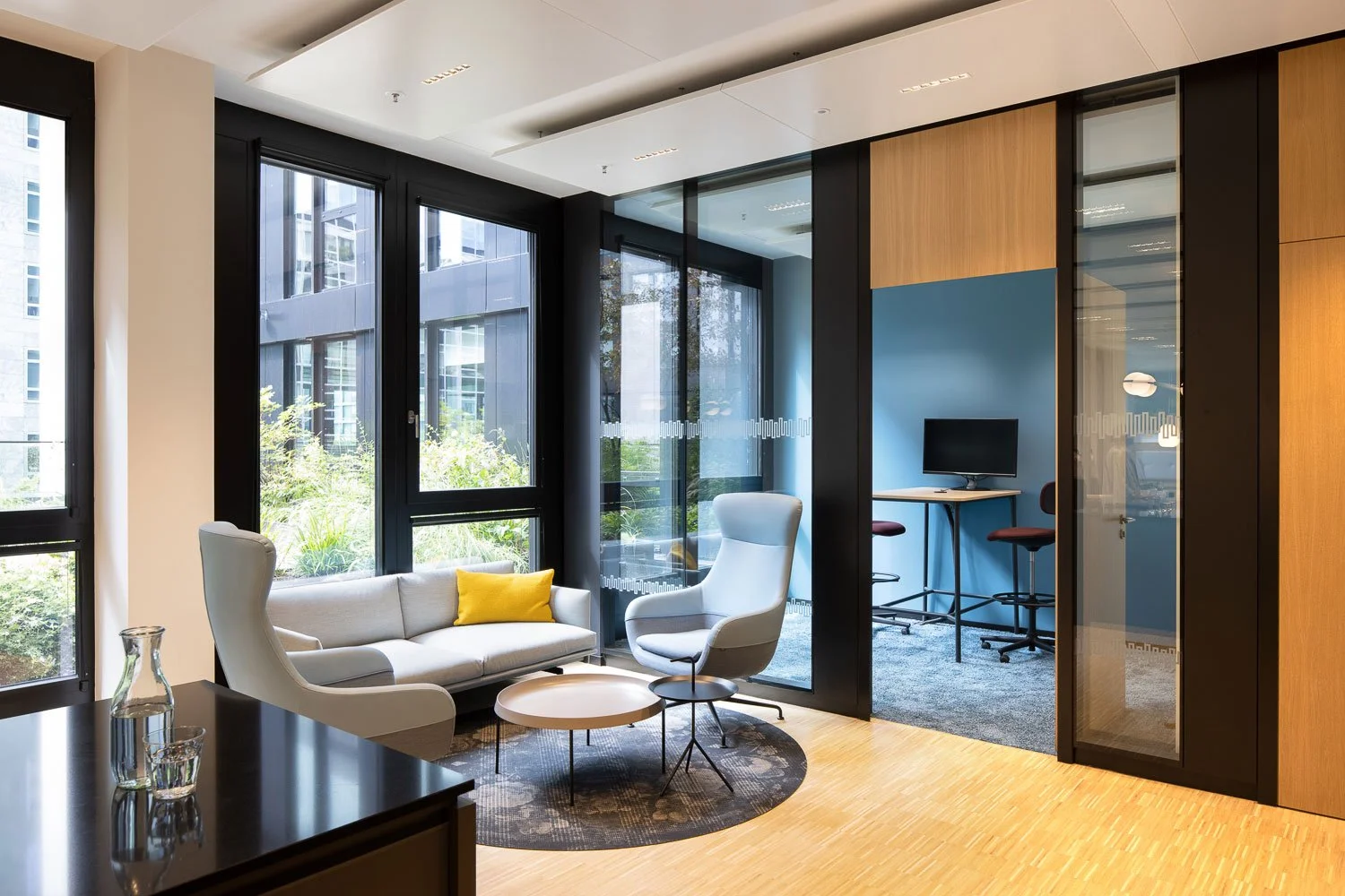 Architekturfotografie einer Büro-Lounge mit HAY DLM Beistelltisch und Blick in einen blauen Fokusraum. Interior-Konzept von Drees & Sommer.