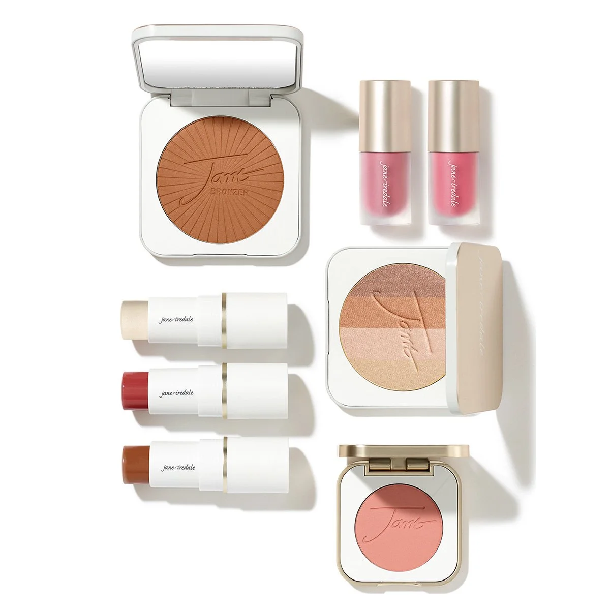 Collection of makeup products including bronzer, blush, and lipsticks featuring neutral and pink tones, arranged on a white background.