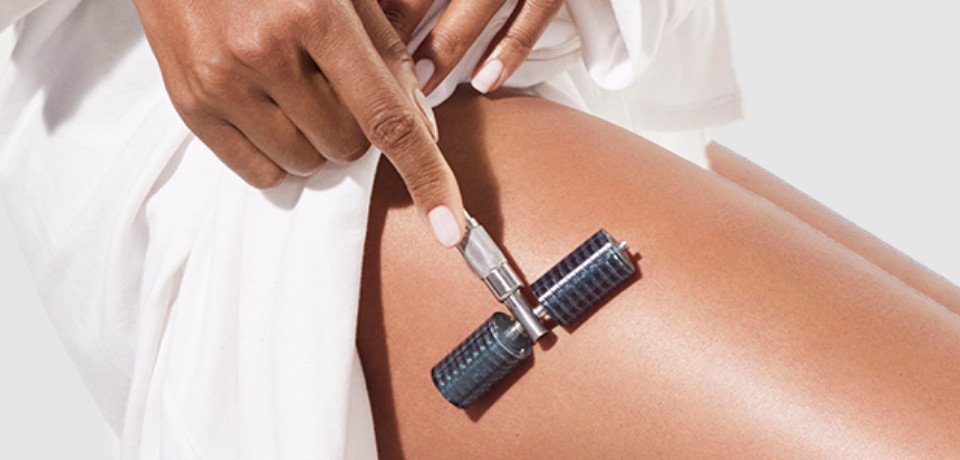 Close-up of a person receiving a waxing treatment on their leg, with a waxing strip being applied by a professional.