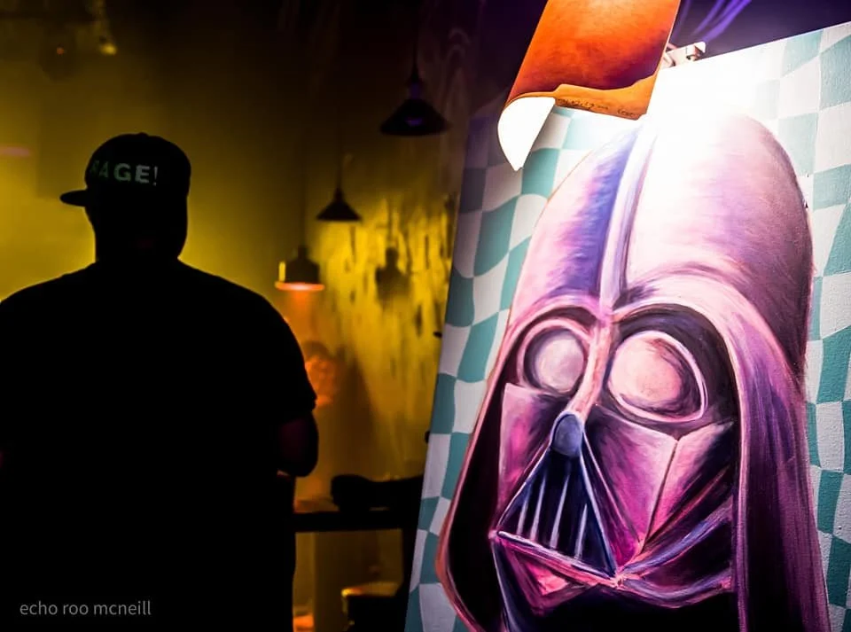 A live painter poses with the final result of a night of painting at a 404 productions EDM event.