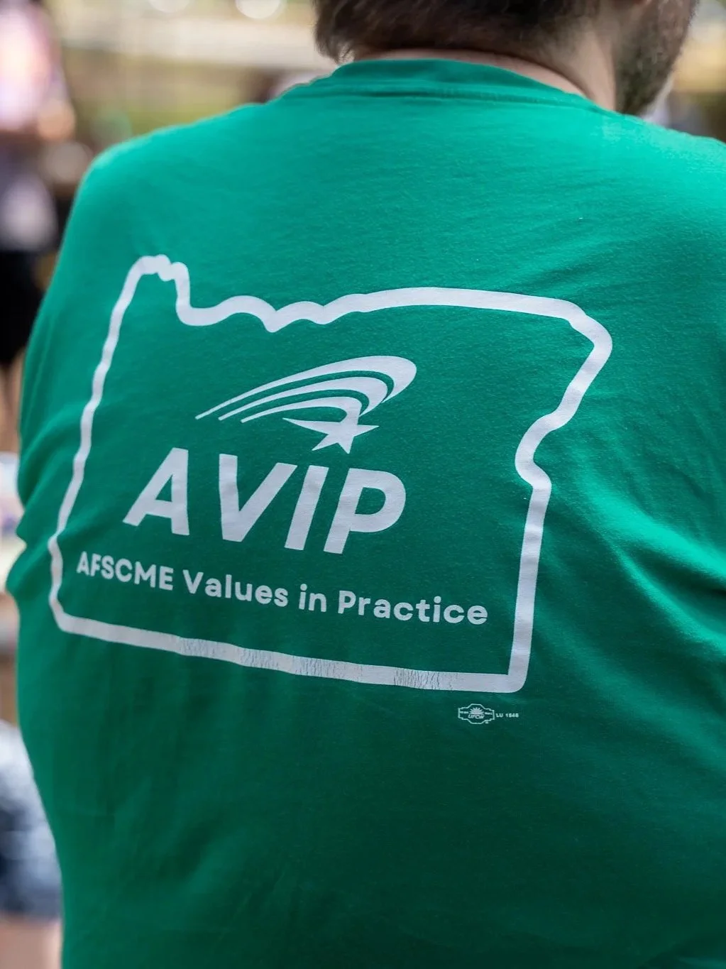 Man wearing green t-shirt with AVIP logo