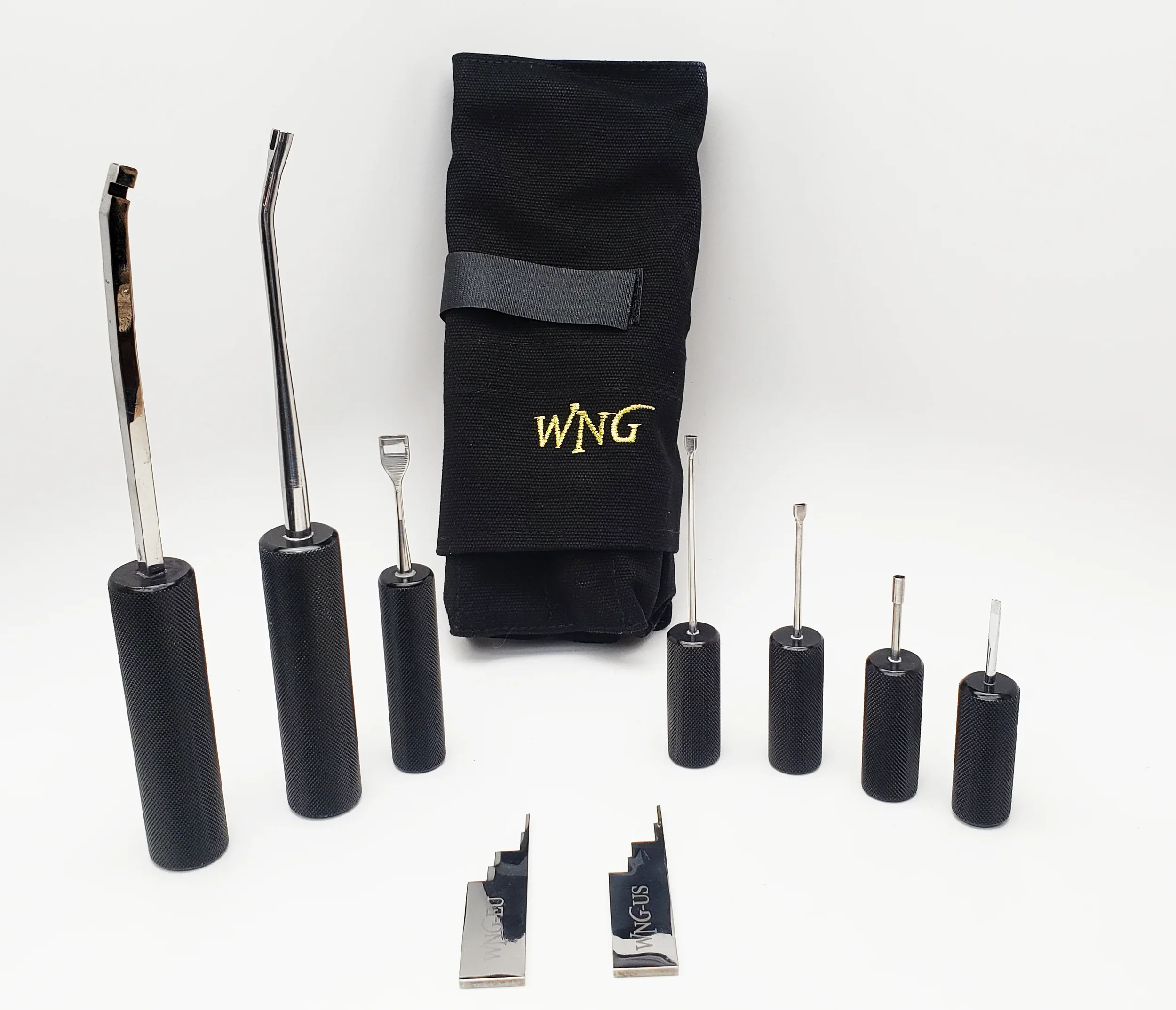 A set of lock picking tools with various hook and tension wrenches, a black carrying case embroidered with yellow letters 'WNG', and two lock pick tension tools, all arranged on a white surface.