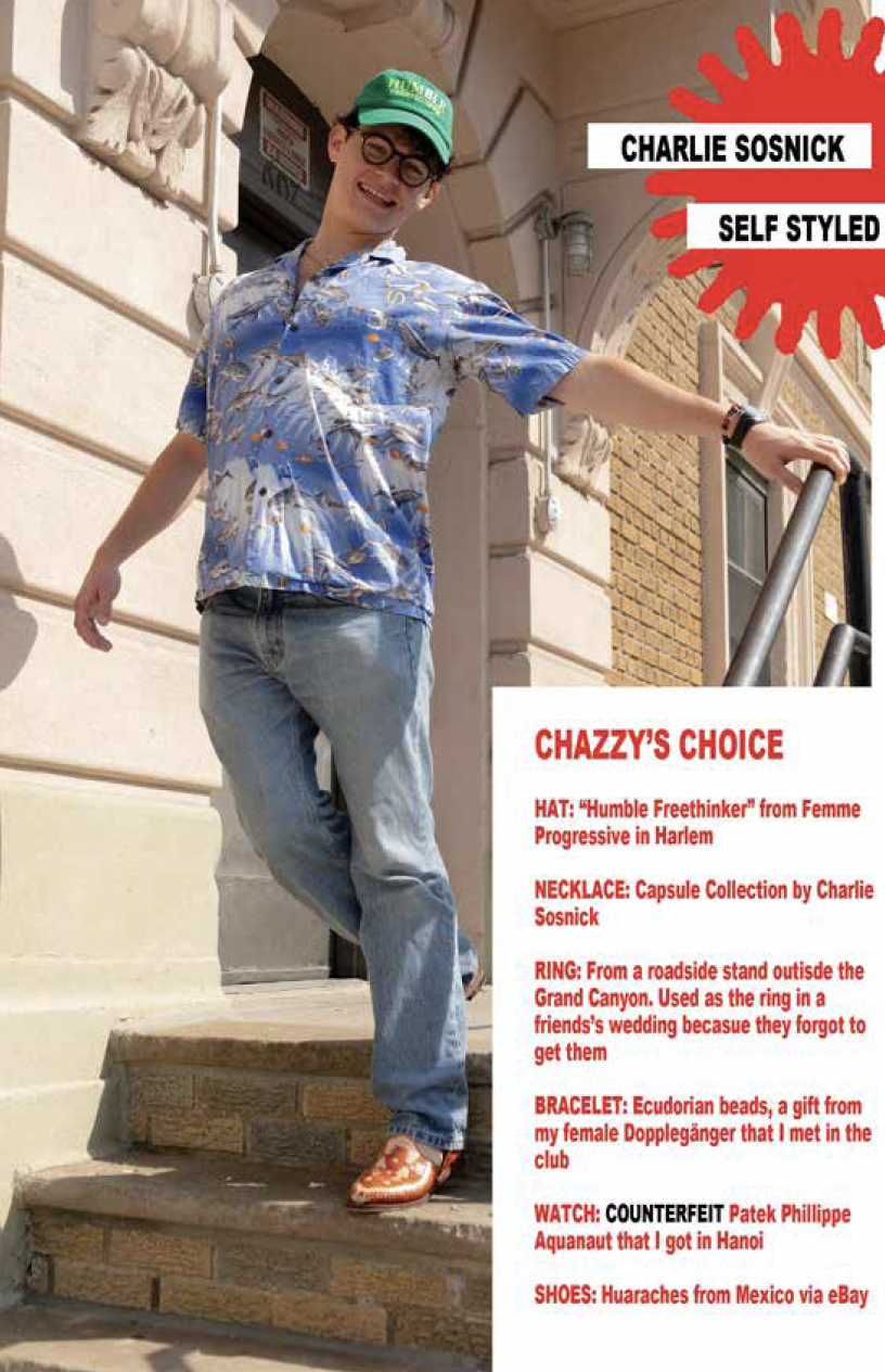 A young man wearing a green cap, glasses, a colorful Hawaiian shirt, and jeans standing on a staircase outdoors, smiling and leaning on a railing, with a building exterior in the background.