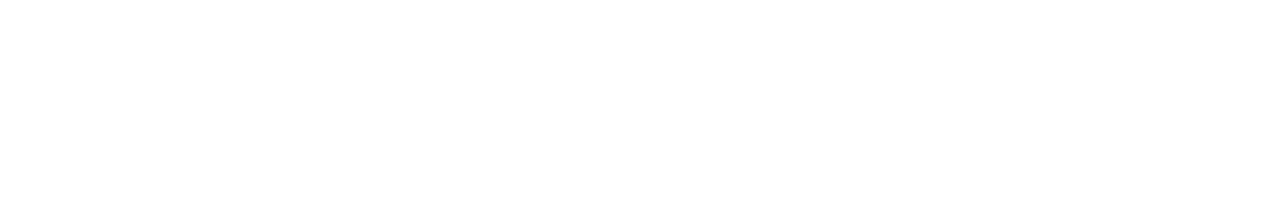 Una taza de café en una mesa de madera con una cuchara y un chocolate en polvo al lado.