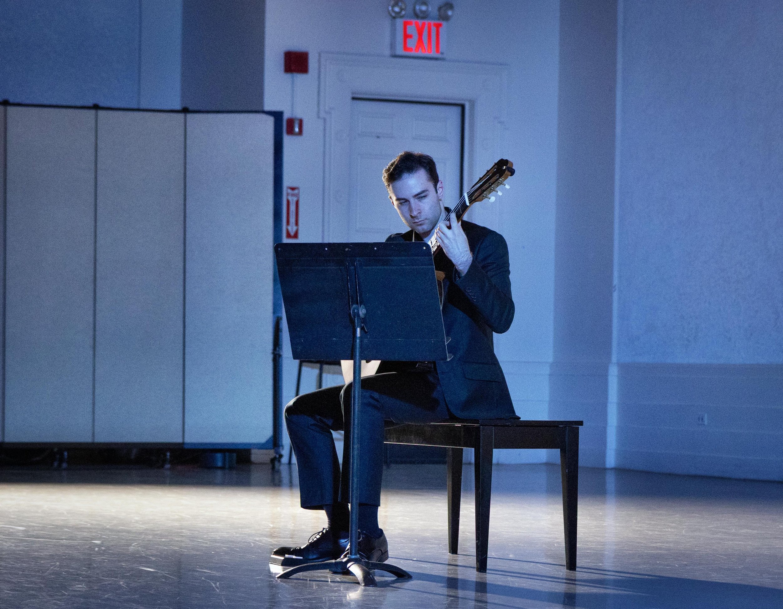 Classical guitarist Max Barker in "A Pop-Up Ballet at New York City Center," an evening of choreography by Kathryn Roszak, presented by Danse Lumière. Photo by Kent G. Becker.