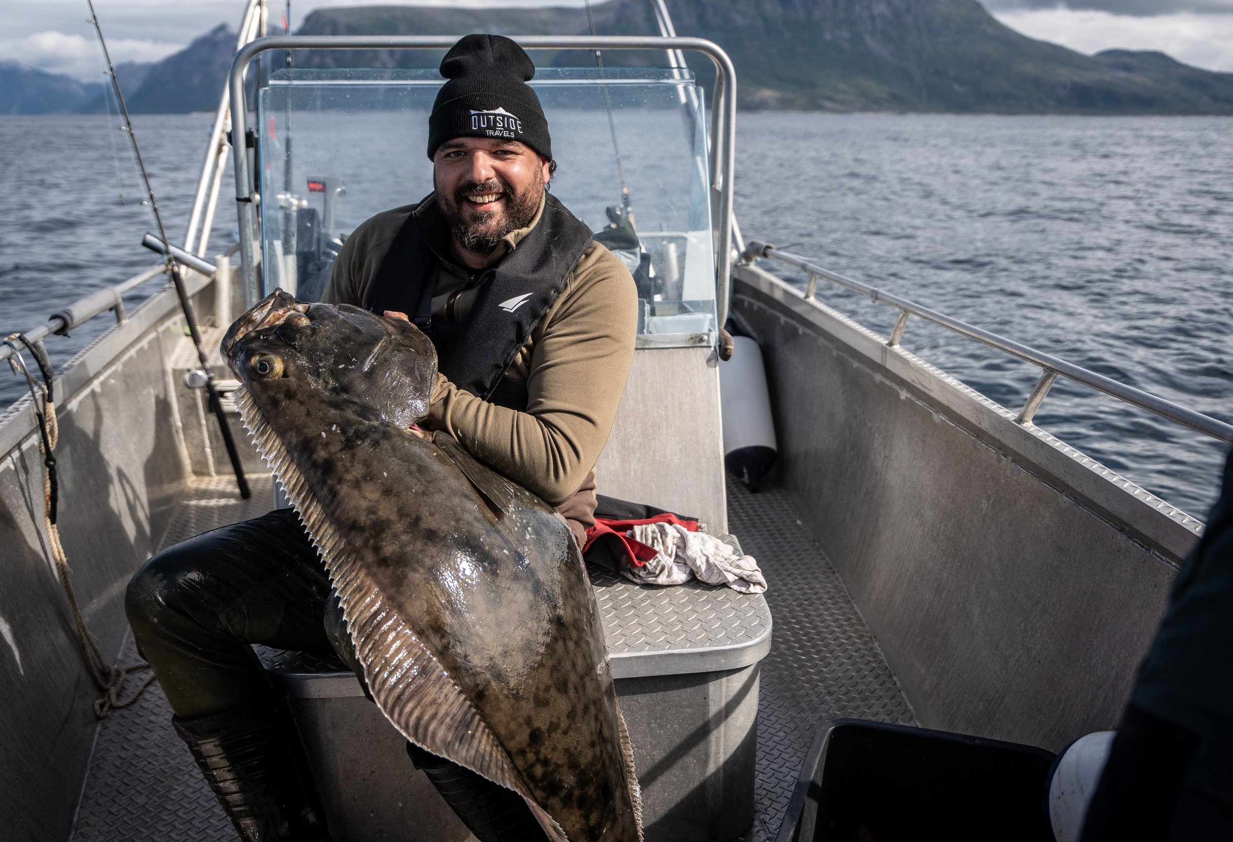 Stolt fiskare visar upp en stor hälleflundra efter lyckat havsfiske vid Frovåg i NorgeStolt fiskare visar upp en stor hälleflundra efter lyckat havsfiske vid Frovåg i Norge