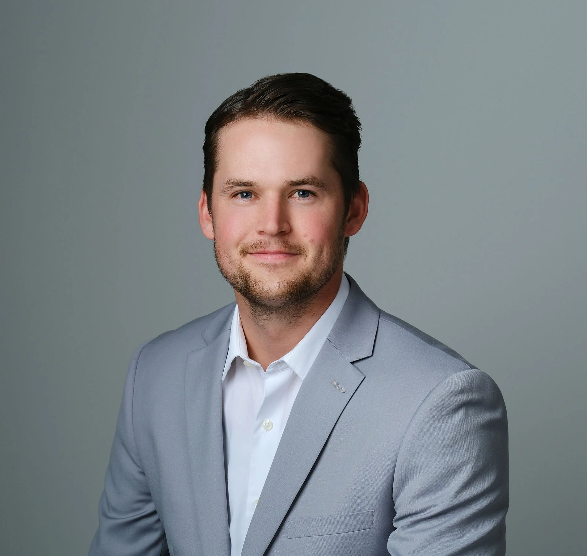 Professional headshot of Ben Jones in gray suit, supporting small company bookkeeping and financial reporting for clients.