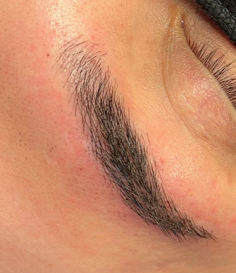 Close-up of a person's closed eye, showing eyelash and eyebrow details.