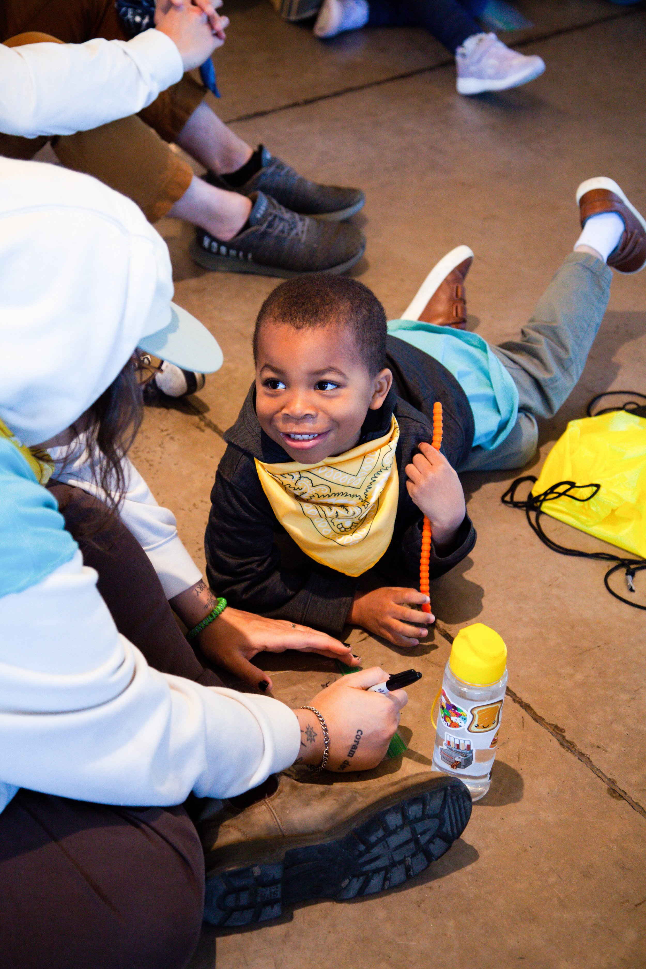 Two young adults lead a group of children in a fun activity.