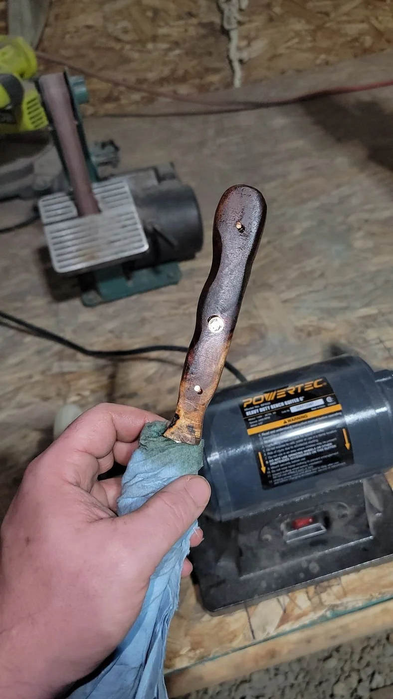 Shaping a knife at the grinder