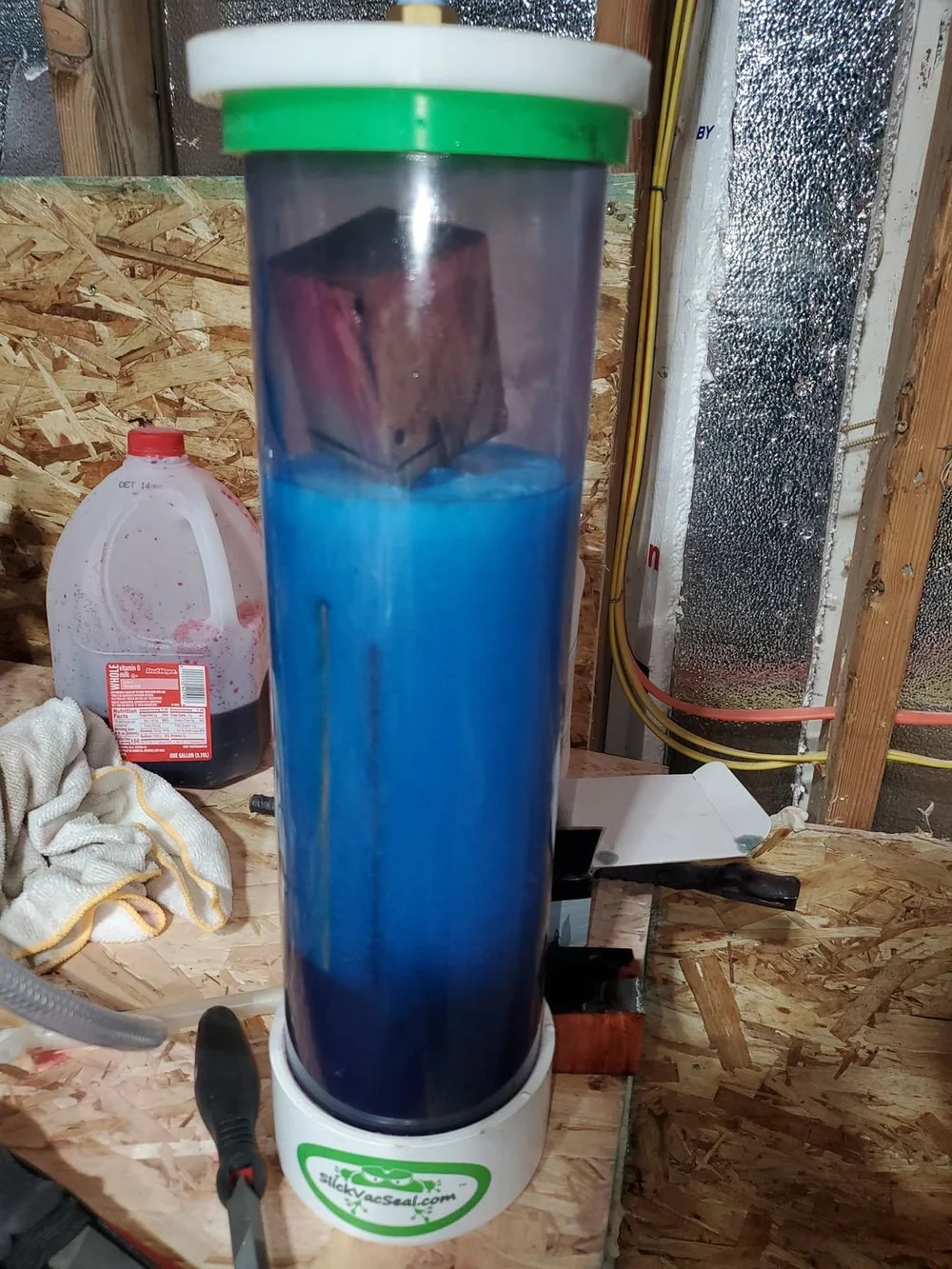 Wood blocks soaking in blue resin inside the vacuum chamber