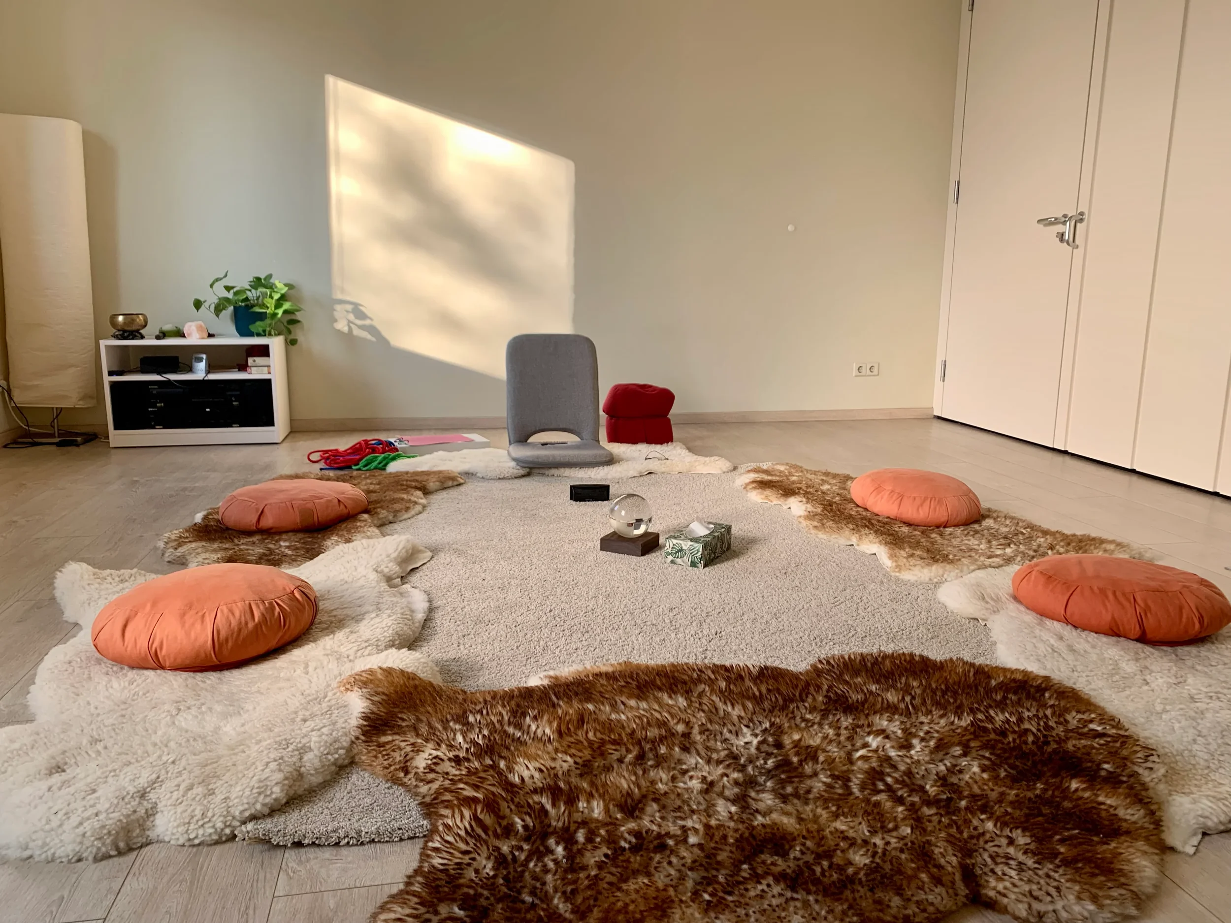 Kreis von Kissen, Stühlen und Fellen im lichtdurchflutetem Seminarraum