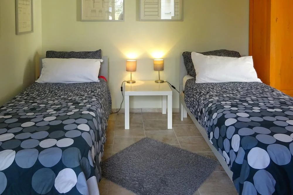  Apartment-Schlafzimmer mit Einzelbetten und blauen Bezügen 