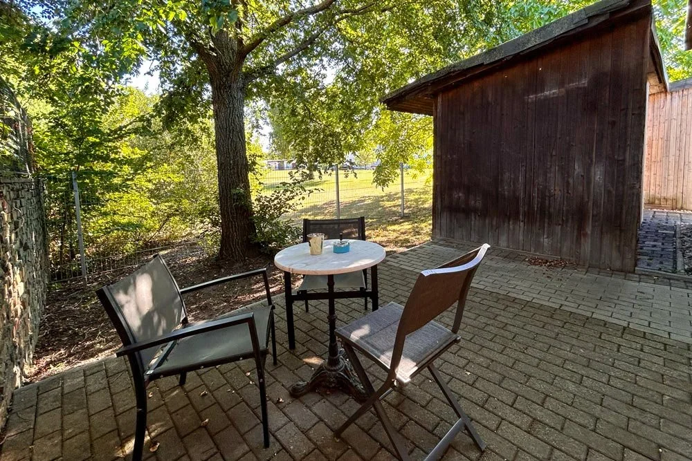  Terrasse mit Backsteinboden und Sitzgelegenheit im Grünen 