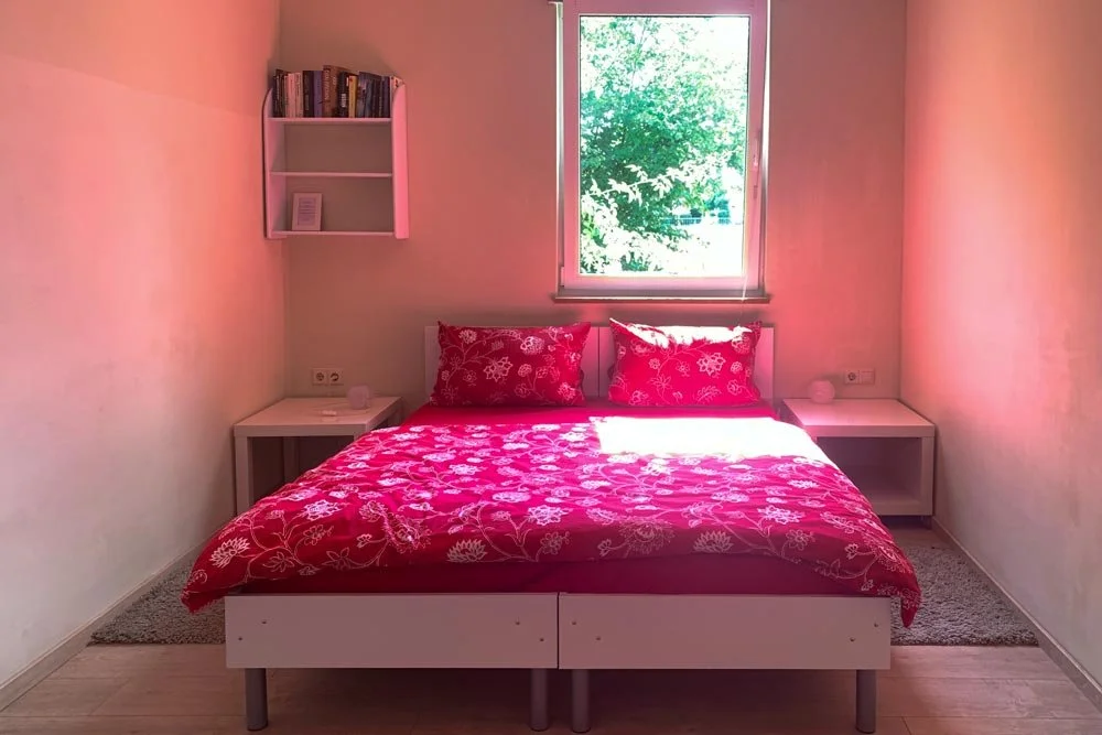  Schlafzimmer mit Doppelbett, Fensterblick und Bücherregal 