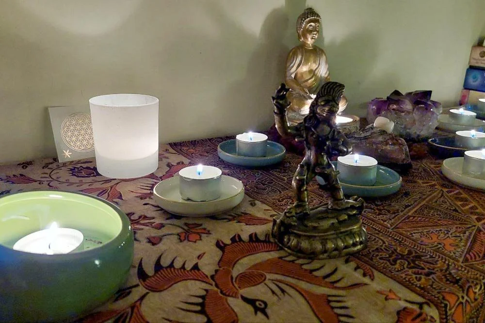  Eine Detailaufnahme, die die stimmungsvolle Dekoration des Denkraums zeigt: Kerzen, eine Buddha-Statue und Kristalle, die eine ruhige Atmosphäre für Ideenraum und Selbsterfahrung schaffen. 