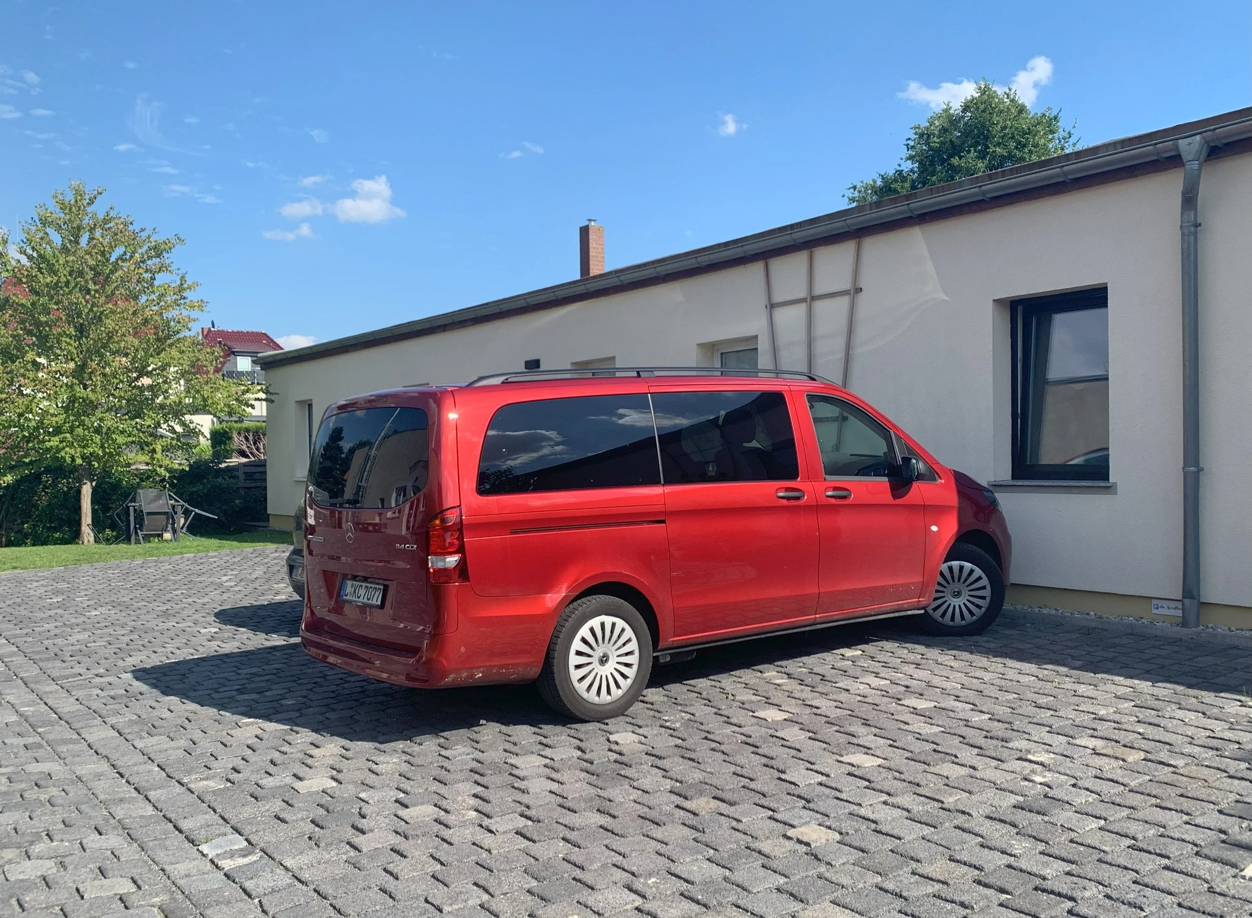 Roter Transporter vor der Senfbude Leipzig – Apartments & Seminarhaus im Leipziger Osten bei Sonnenschein.