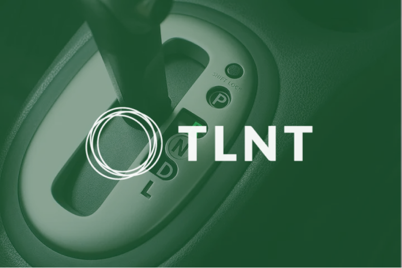 Close-up of a car gear shift with an overlay of the text 'TLNT' and a circular design.