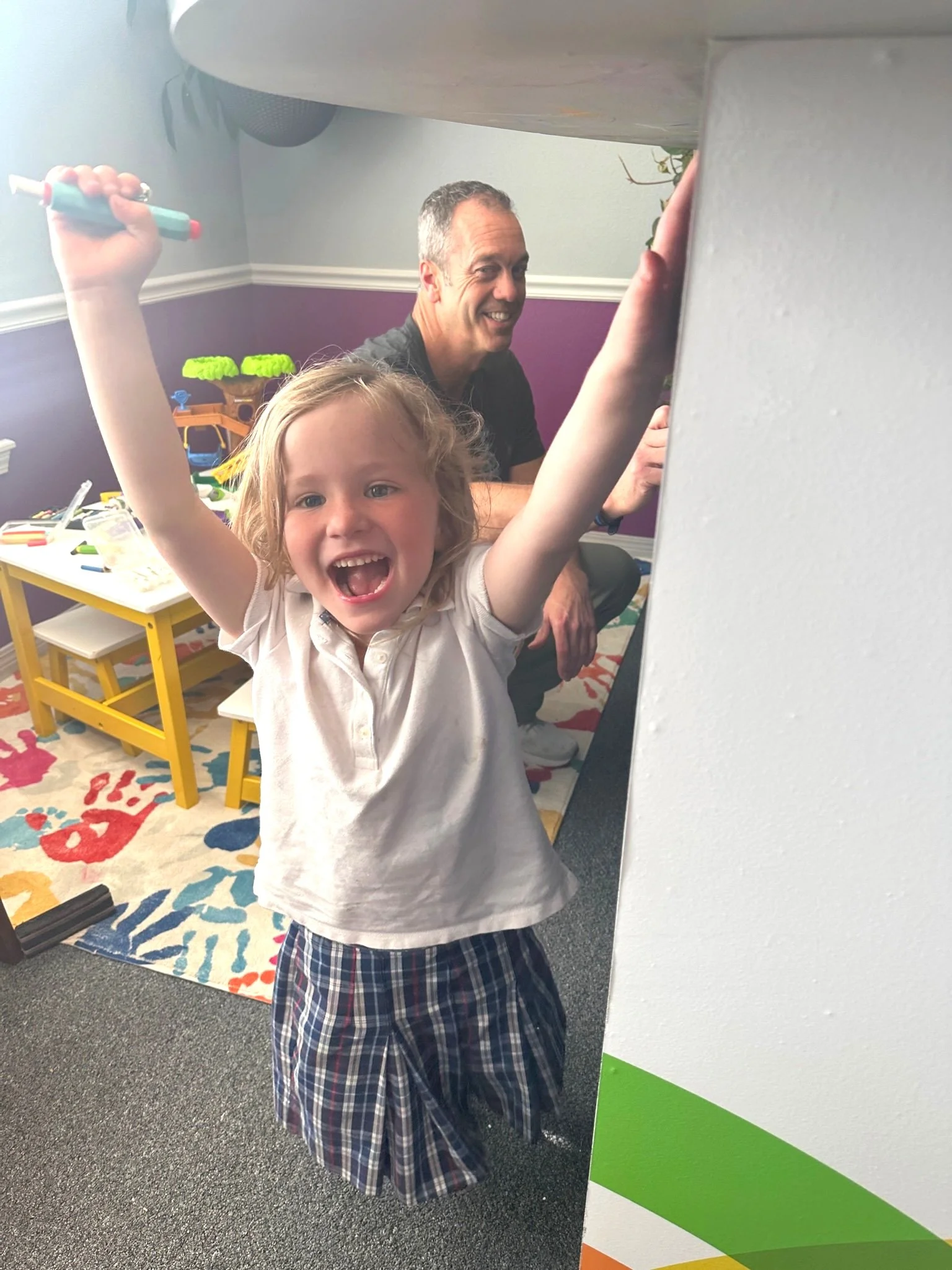 Dr. Drake coloring on chalkboard with young patient