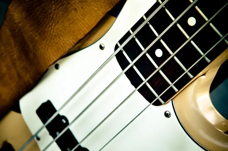 close up photo of a Fender Precision bass guitar in cream color