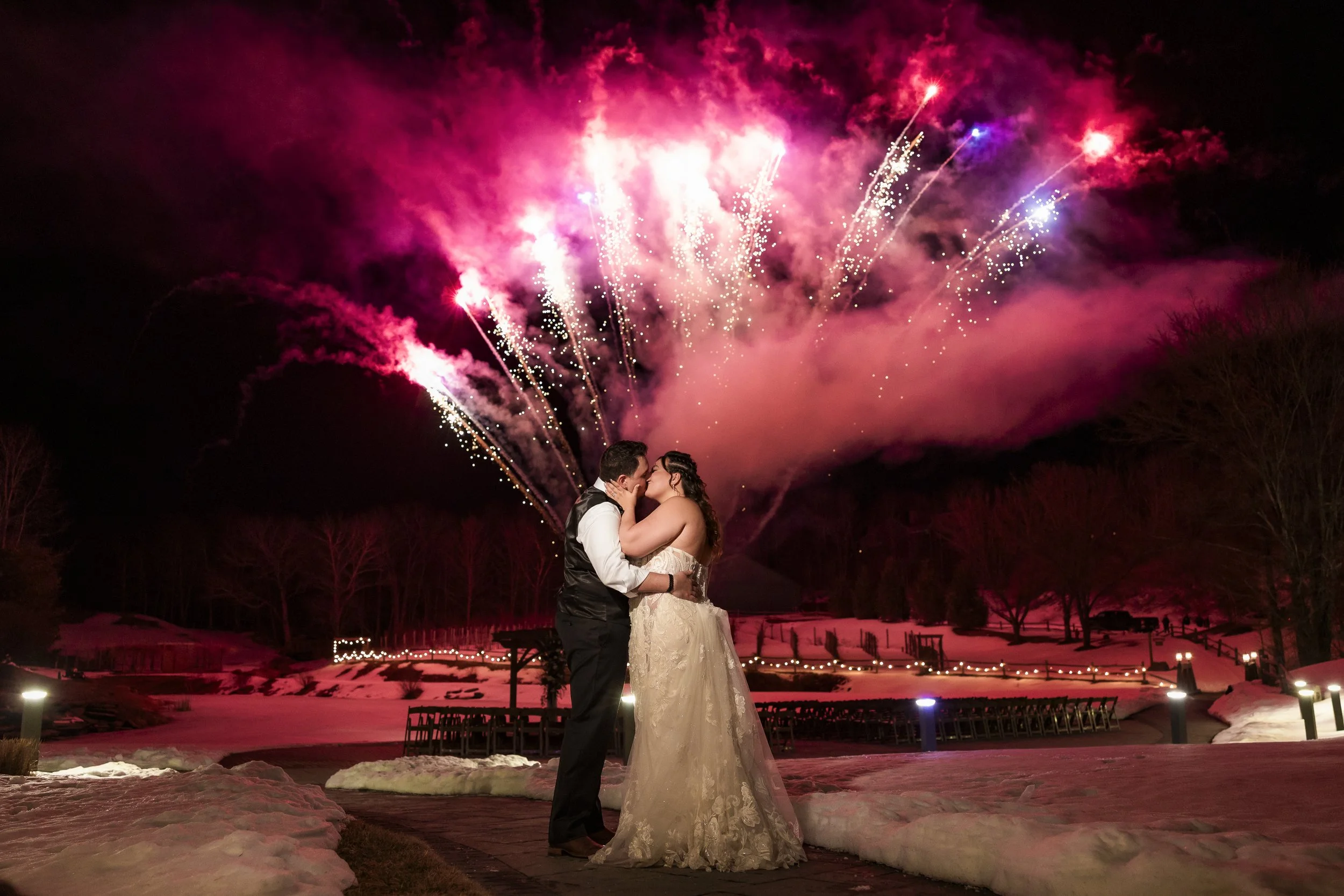 a husband and wife sharing a kiss on their wedding night with fireworks