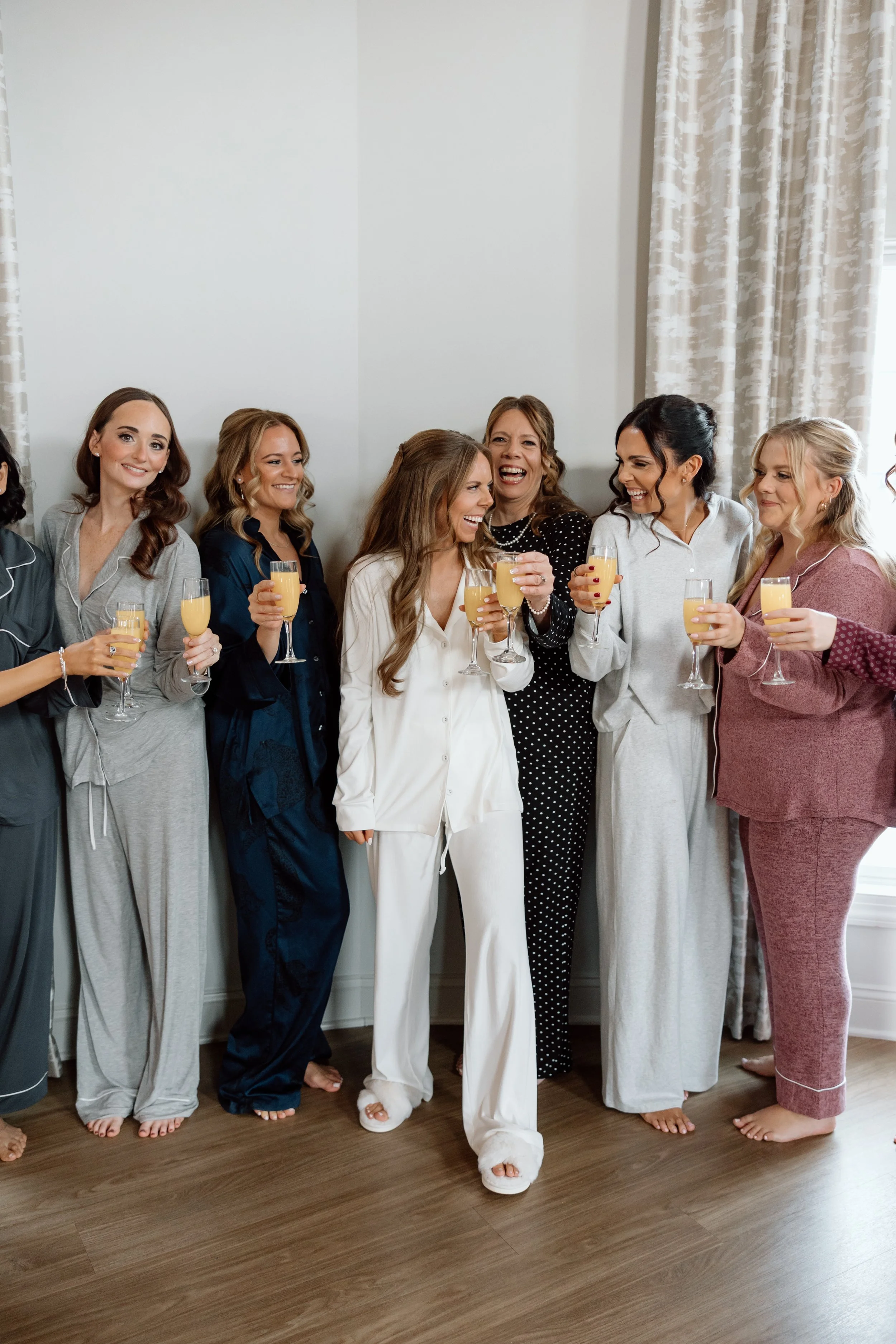 Bridesmaids and bride drinking mimosas in the bridal suite.