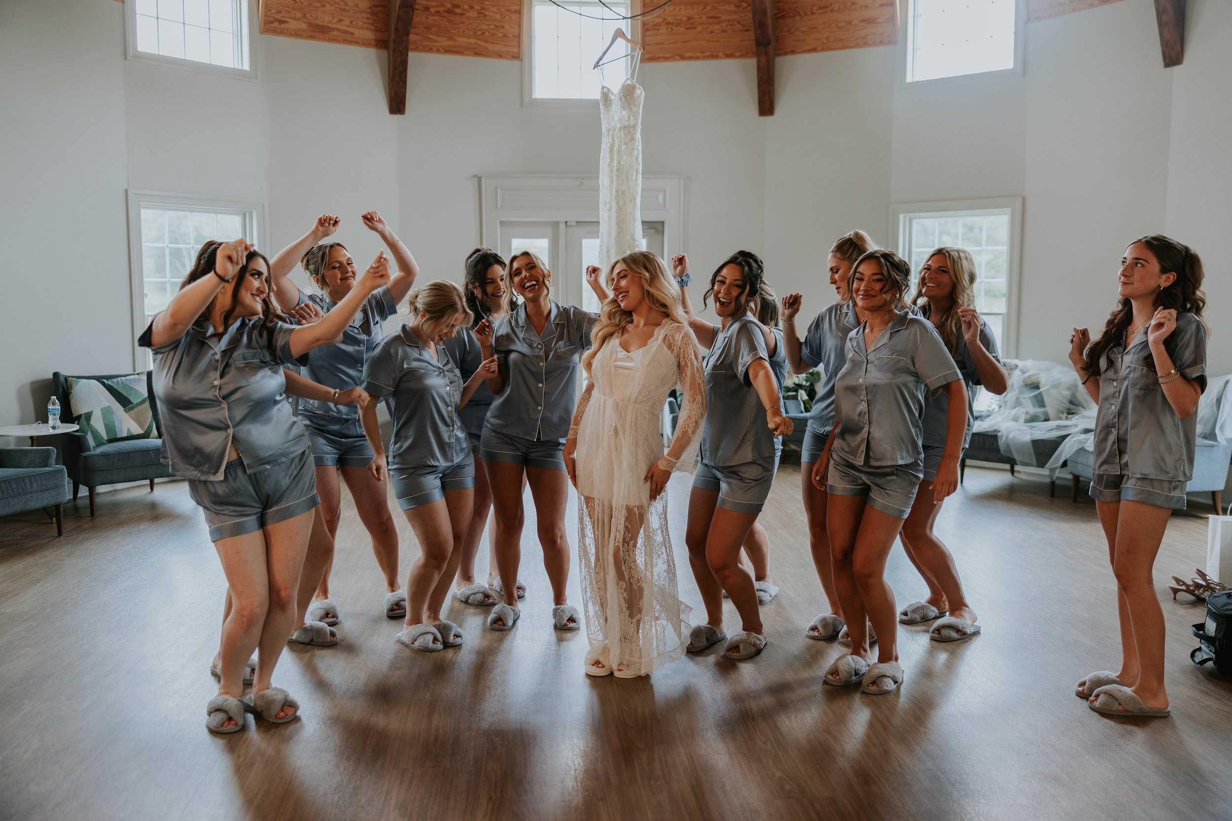 Bride and bridesmaids dancing in pajamas in the bridal suite.