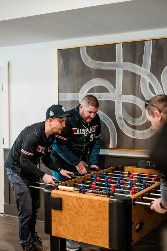 Groomsmen playing foosball.