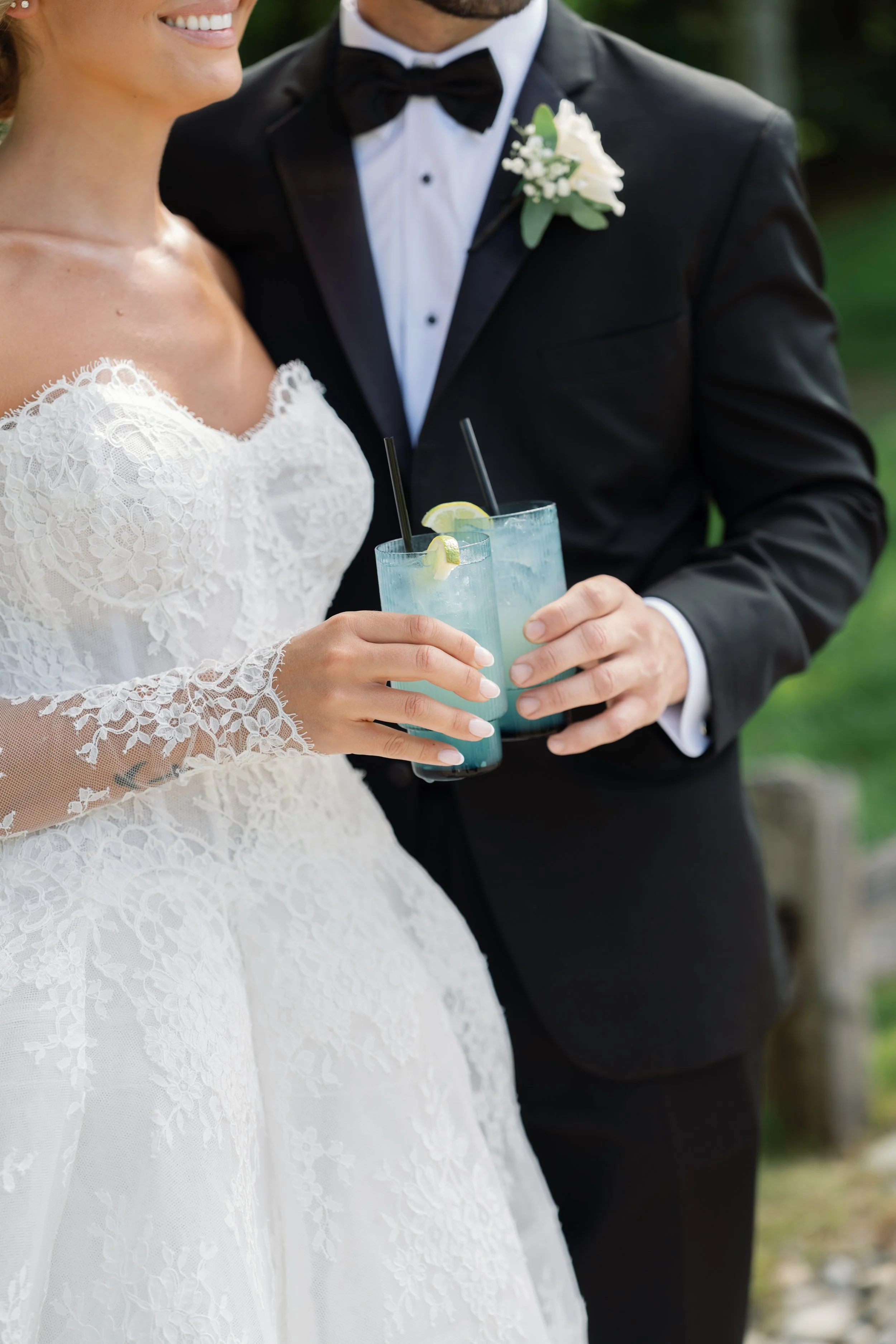 bride and groom sharing a blue cocktail