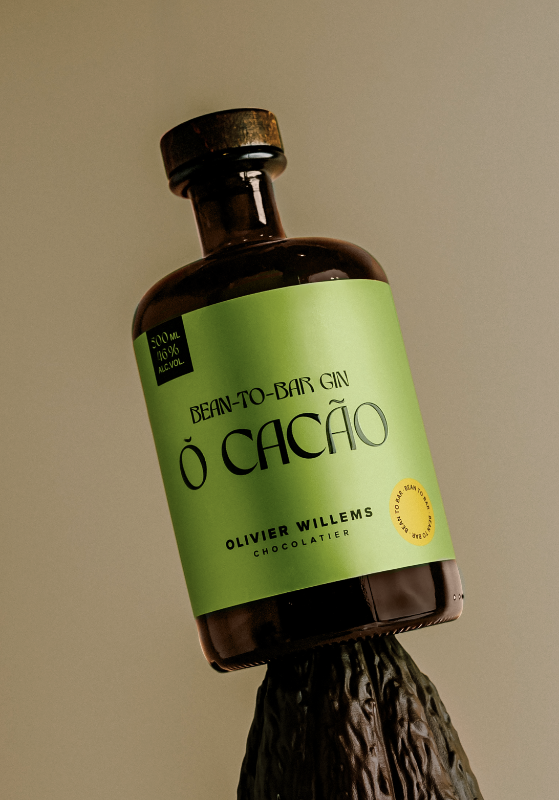 An apothecary bottle with a green label reading 'Bean-to-Bar Gin Õ Cacaõ'. A cacao gin created by Chocolatier Olivier Willems.