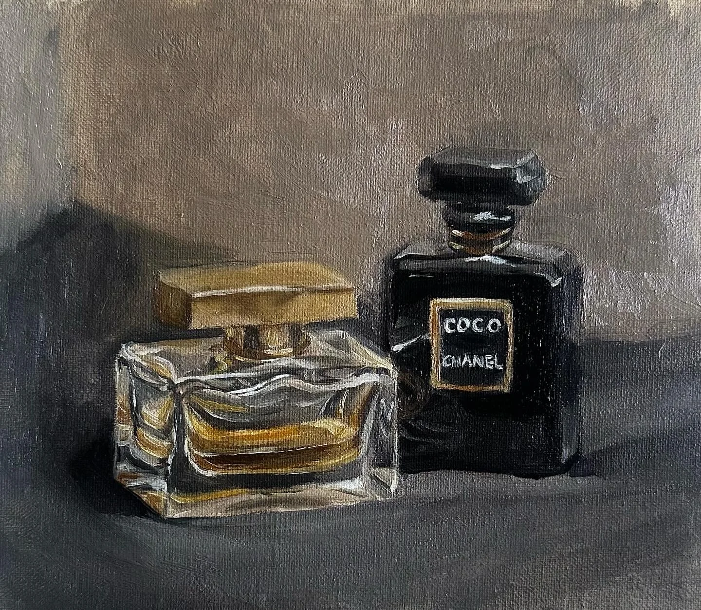 Still life painting of two bottles of perfume, one labeled 'Coco Chanel' in black with a black cap, and a transparent square bottle with a golden cap, set on a dark surface.