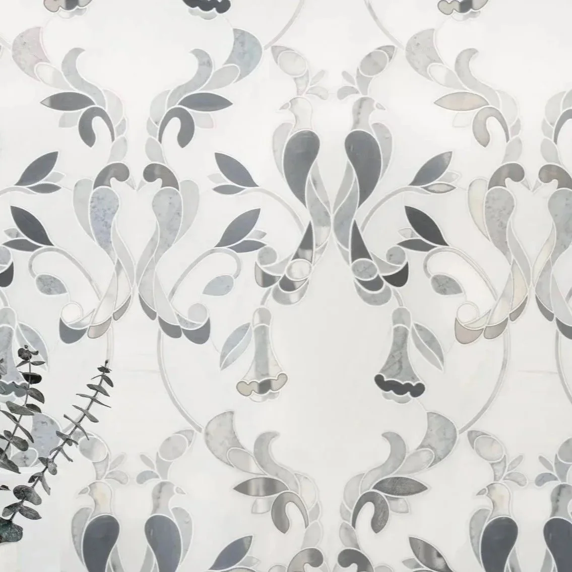 A decorative wallpaper with a symmetrical floral pattern in shades of gray, black, and white.