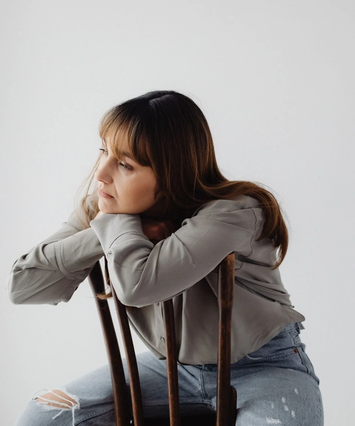 woman sitting on a chair backwards leaning on the back of the chair