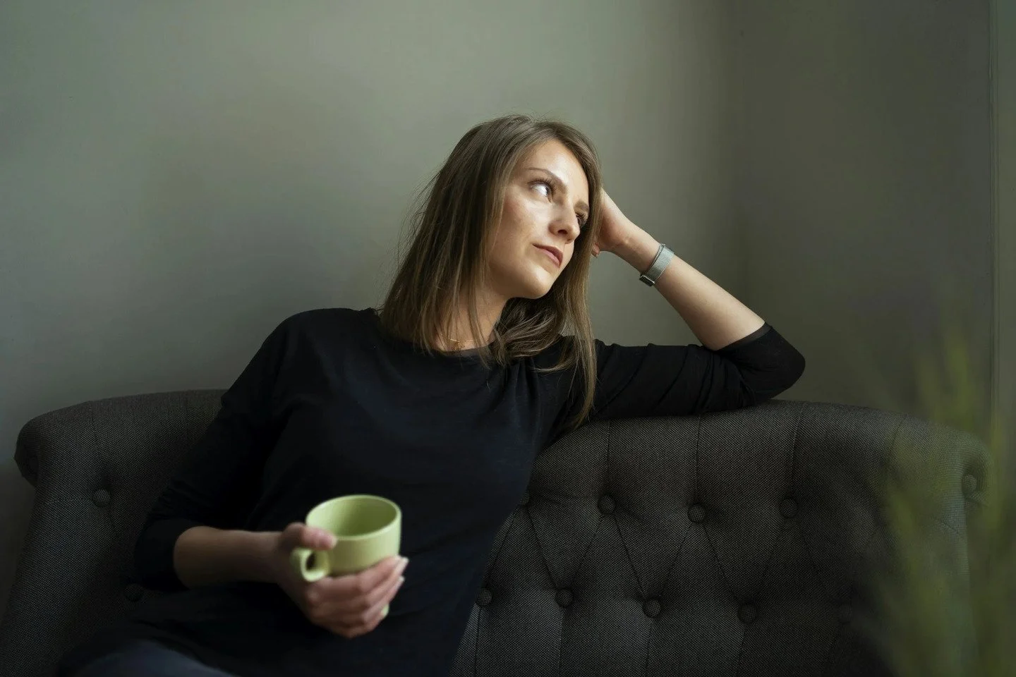 young woman sitting on a couch with coffee