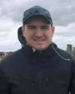 A man with a ball cap and black jacket