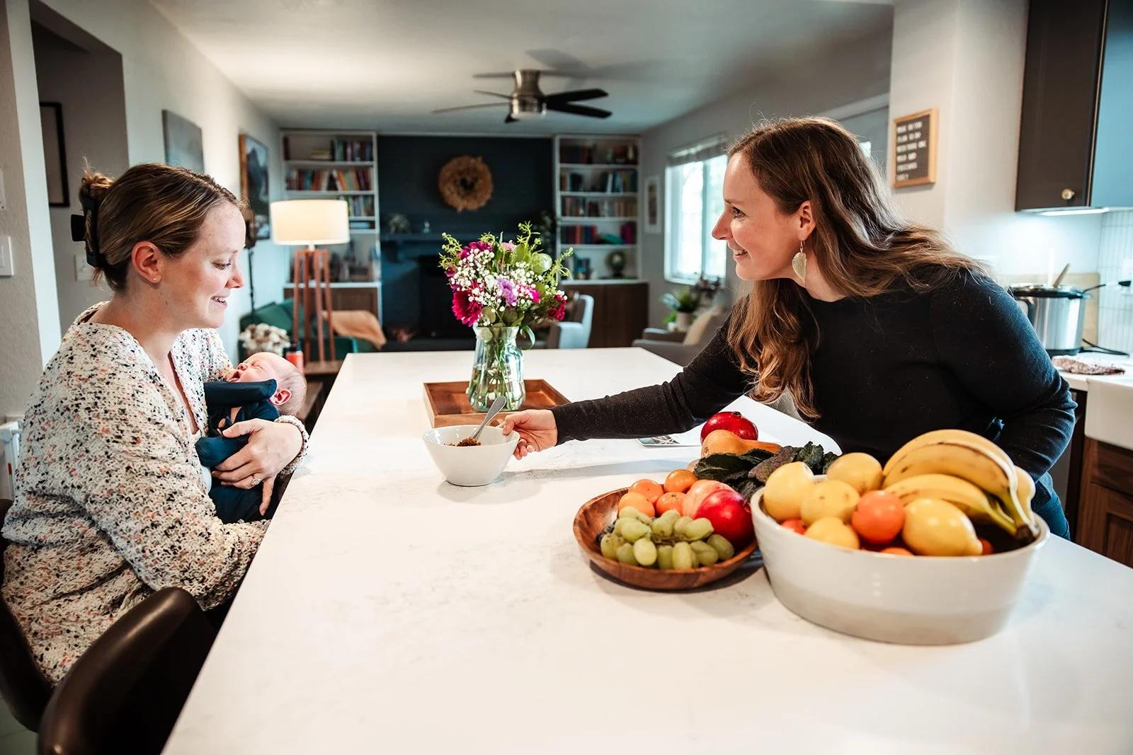 Karina Wenker, Nutritionist, handing a nourishing meal to a postpartum mother holding a newborn