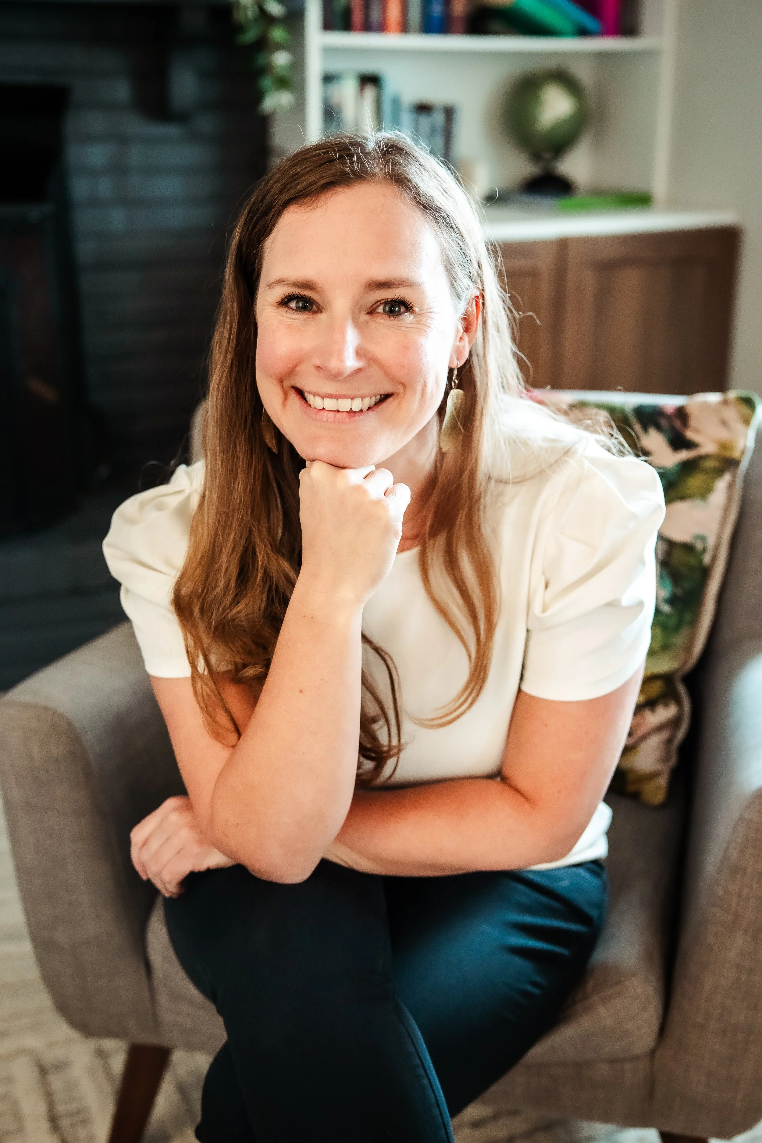Nutritionist Karina Wenker is sitting in a chair, leaning forward smiling into the camera.