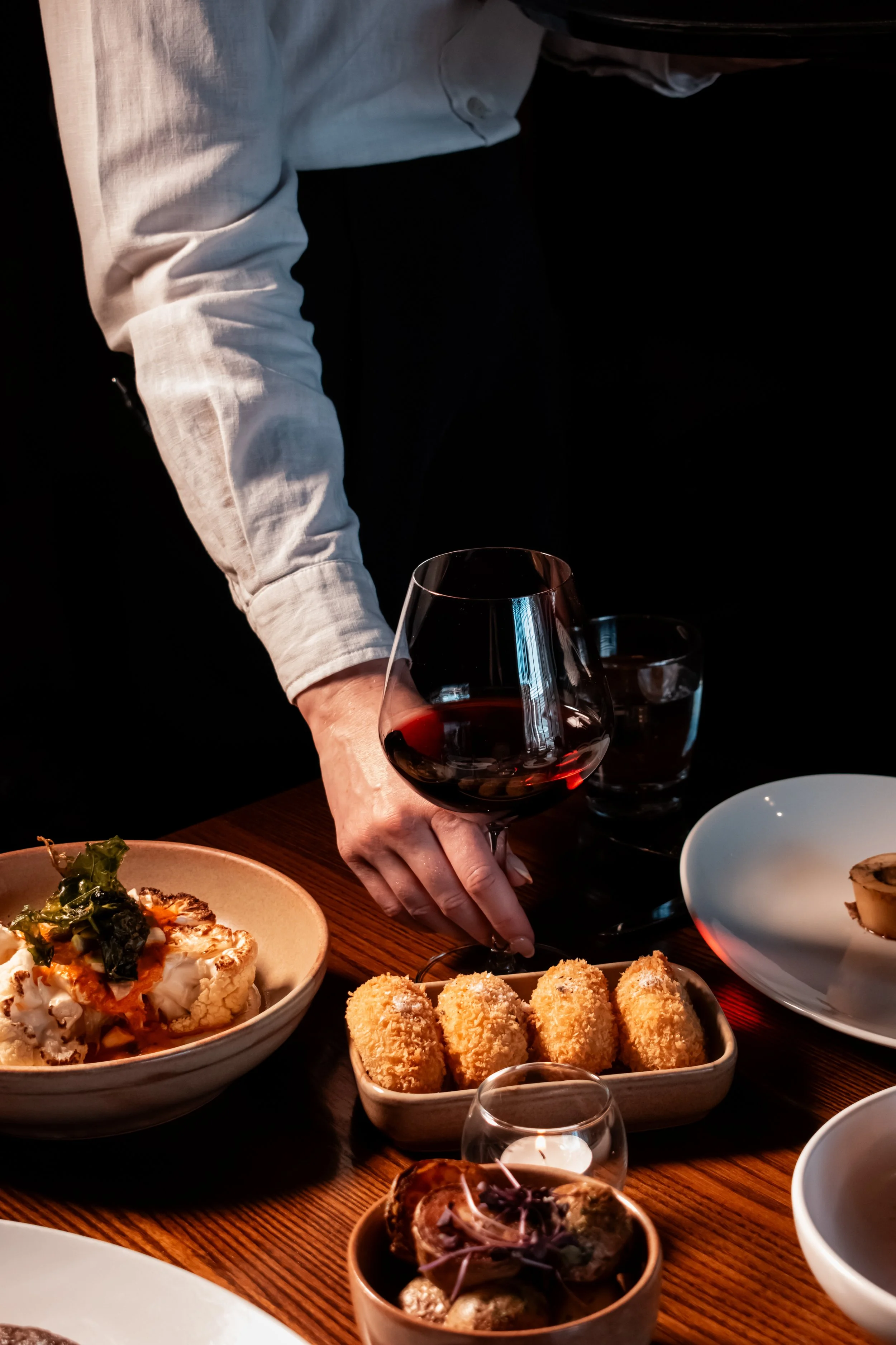 Dining at Bessie in Christchurch, with shared dishes and red wine being served