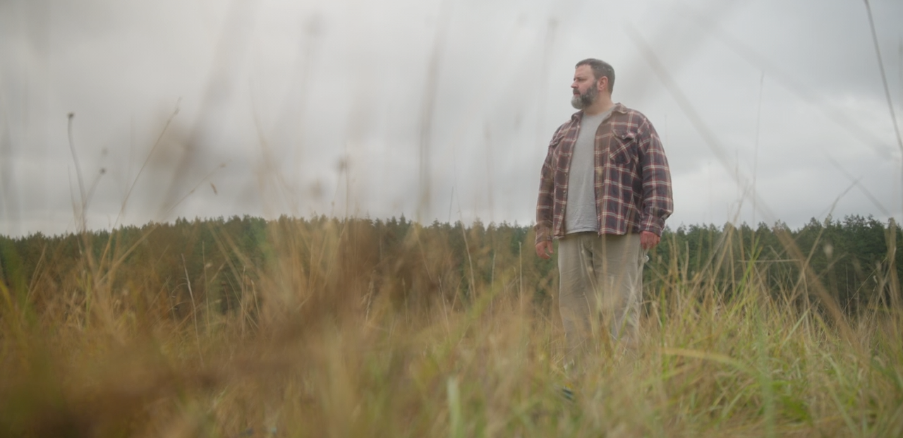 Jay (Logan) looks for Ash in a grassy field