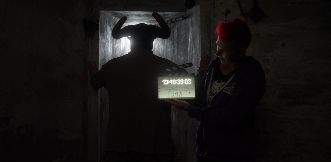 Horns (Logan) prepares to pounce as Writer/Director/Producer (Ren) wields the slate