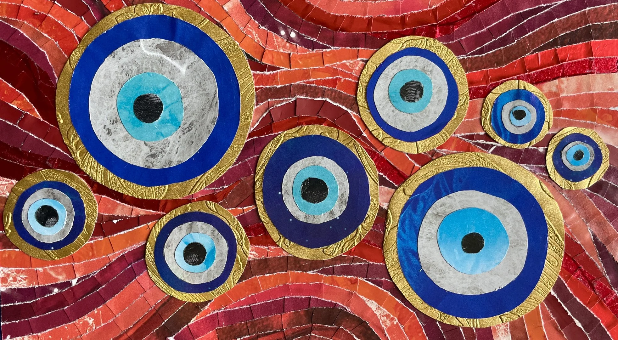 *"Kinehora 1" (2024). Apaper collage of nazars, charms against the evil eye shaped like eyes themselves, against a swirling red and gold background.