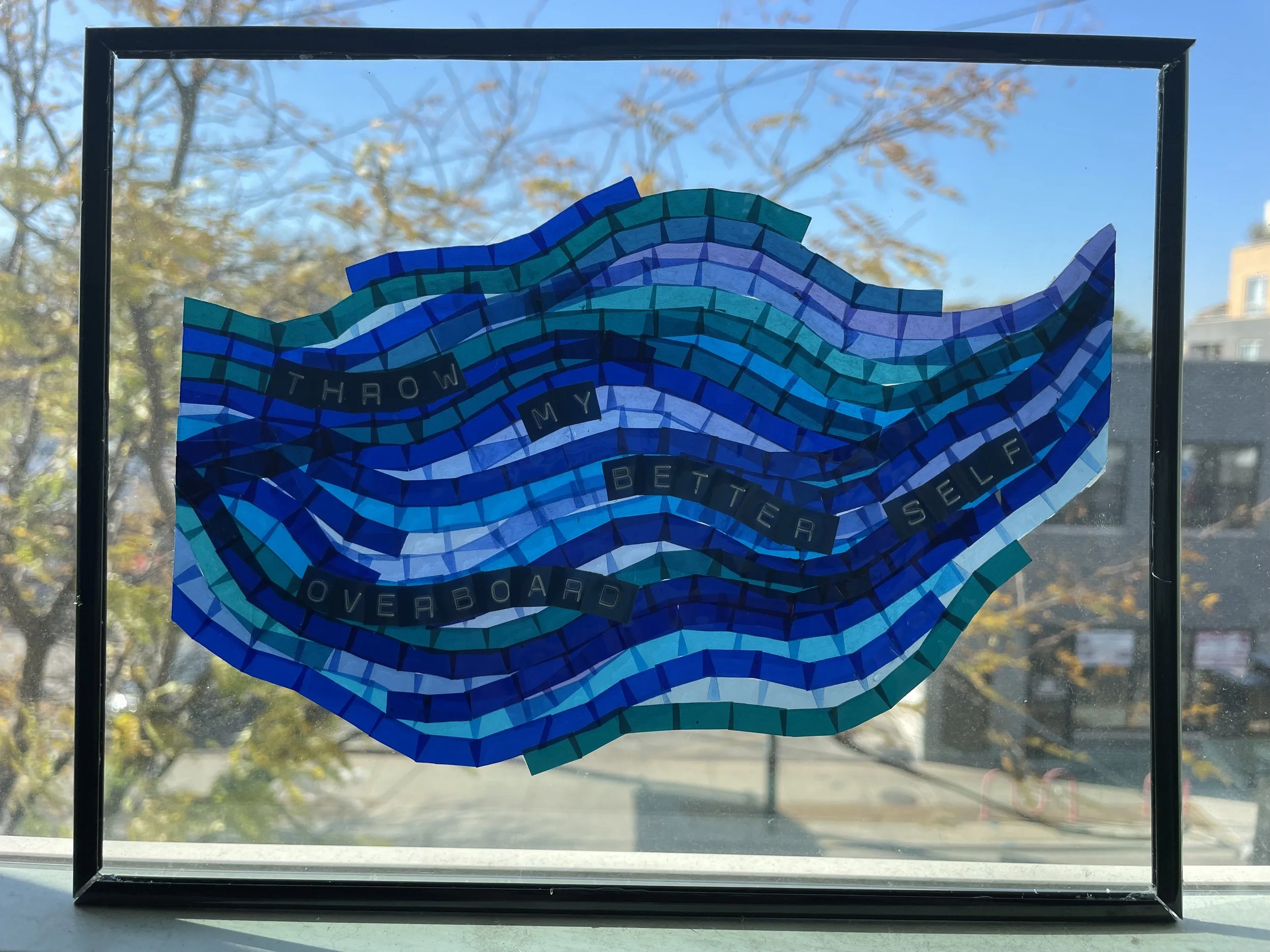 "Throw My Better Self Overboard" (2021). An art piece made of segments of colored plastic, laid out in lines to create overlapping waves in shades of blue and green. Text in Dymo-style block lettering winds through it: “THROW MY BETTER SELF OVERBOARD
