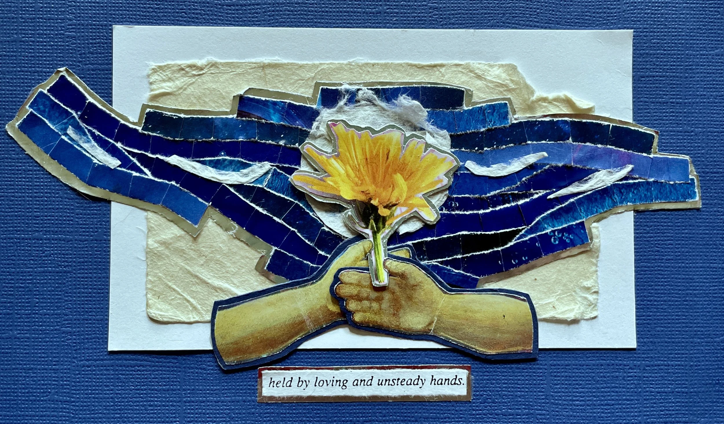 *"Loving and Unsteady Hands" (2024). 5.5"x7.5". A paper collage piece in deep blues, silver, and soft whites. A flowering yellow dandelion is framed by overlapping, twisting lines of blue paper, backed with silver. Something resembling a moon or a da