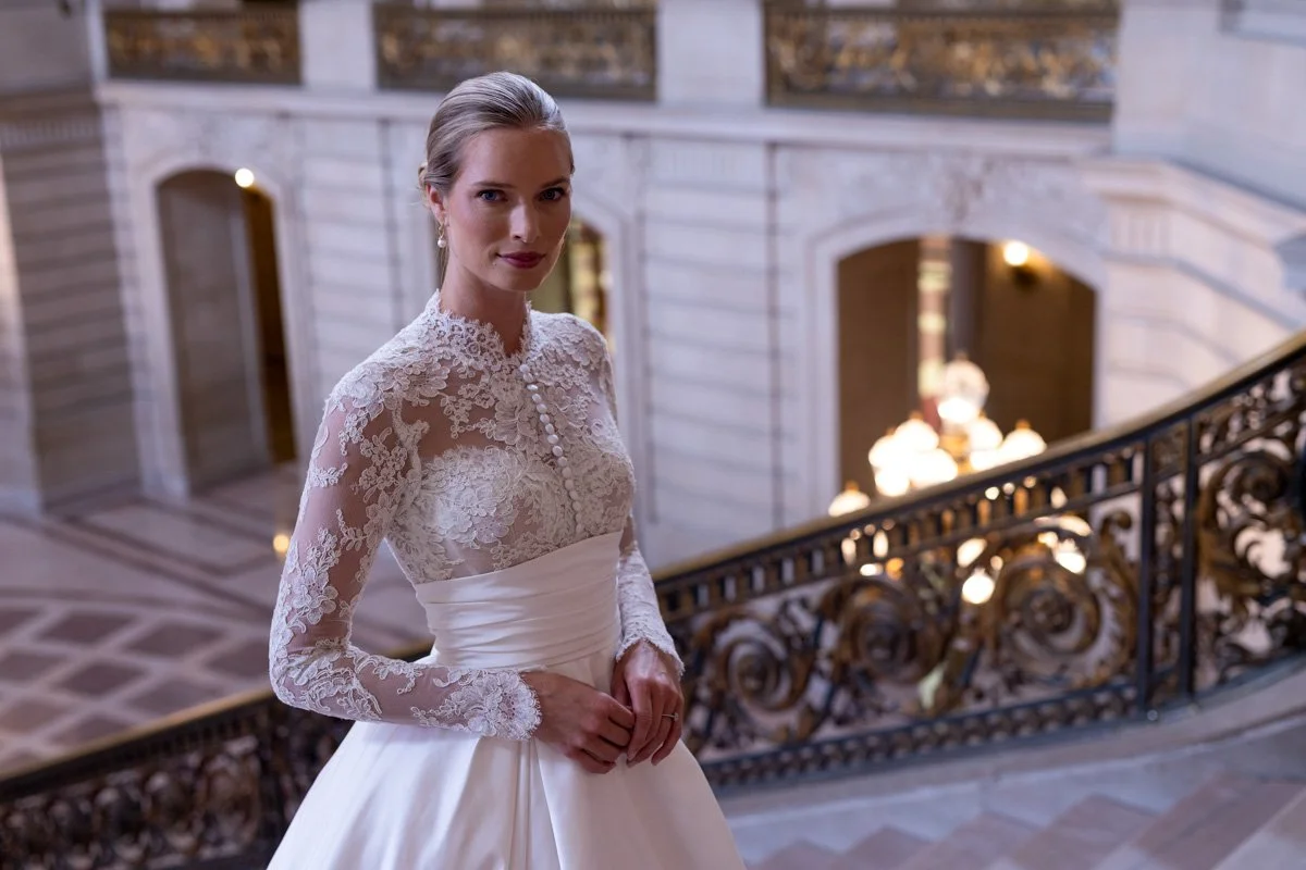 Photo of a model ascending a marble staircase while wearing a wedding dress.