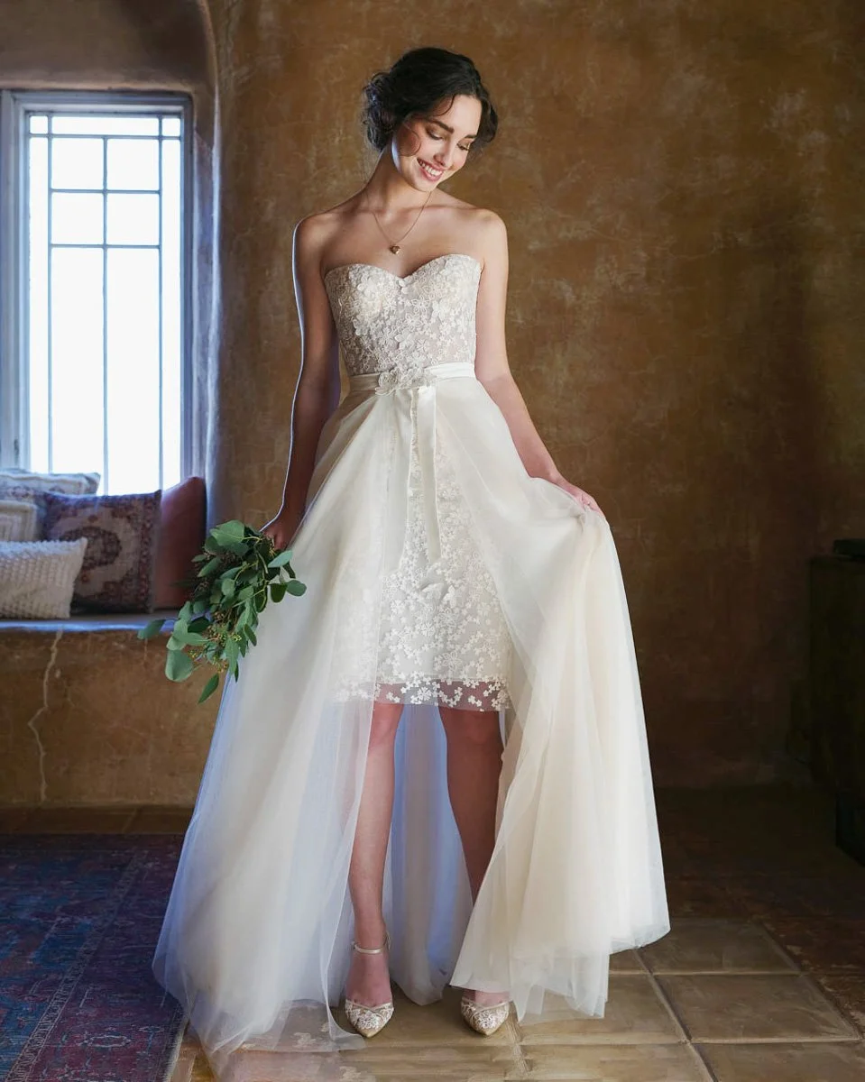 Bride posing wedding gown with a short skirt.