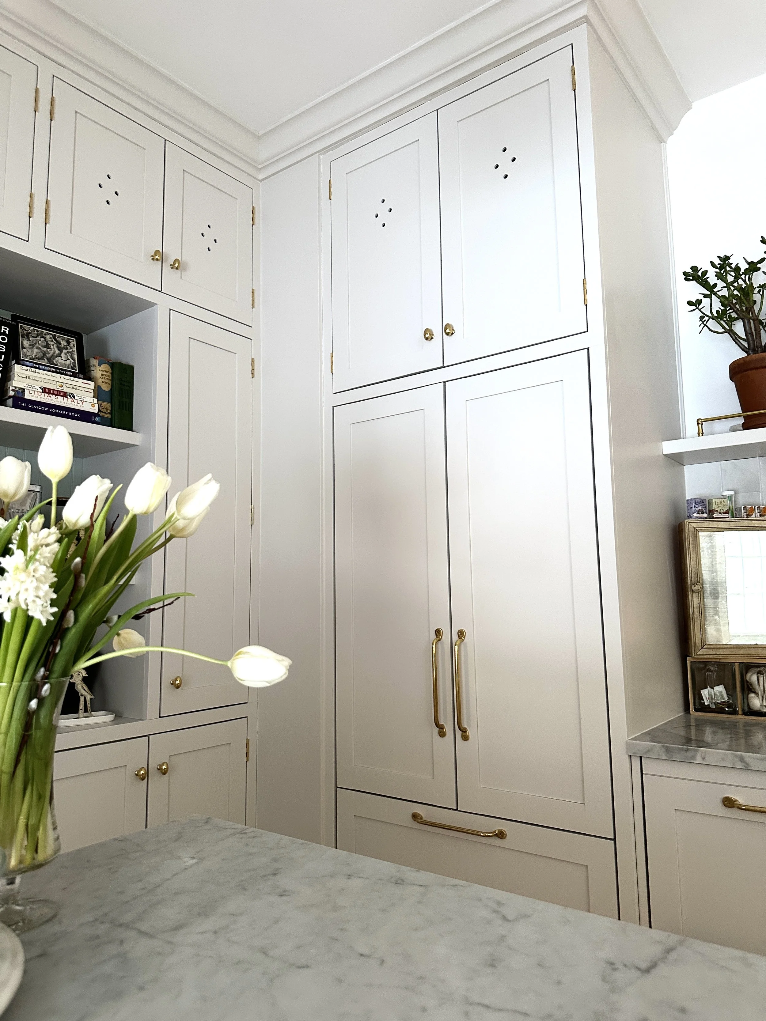 Shaker kitchen with brass hardware and traditional crown moulding 
